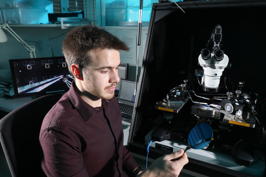 Guillherme Migliato Marega, the lead author on the two papers, inspecting a wafer with MoS2 circuits (Credit: Allain Herzog, EPFL)