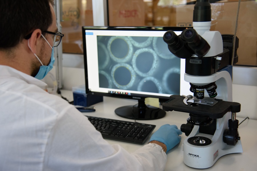 man looking at a microscope image on a screen